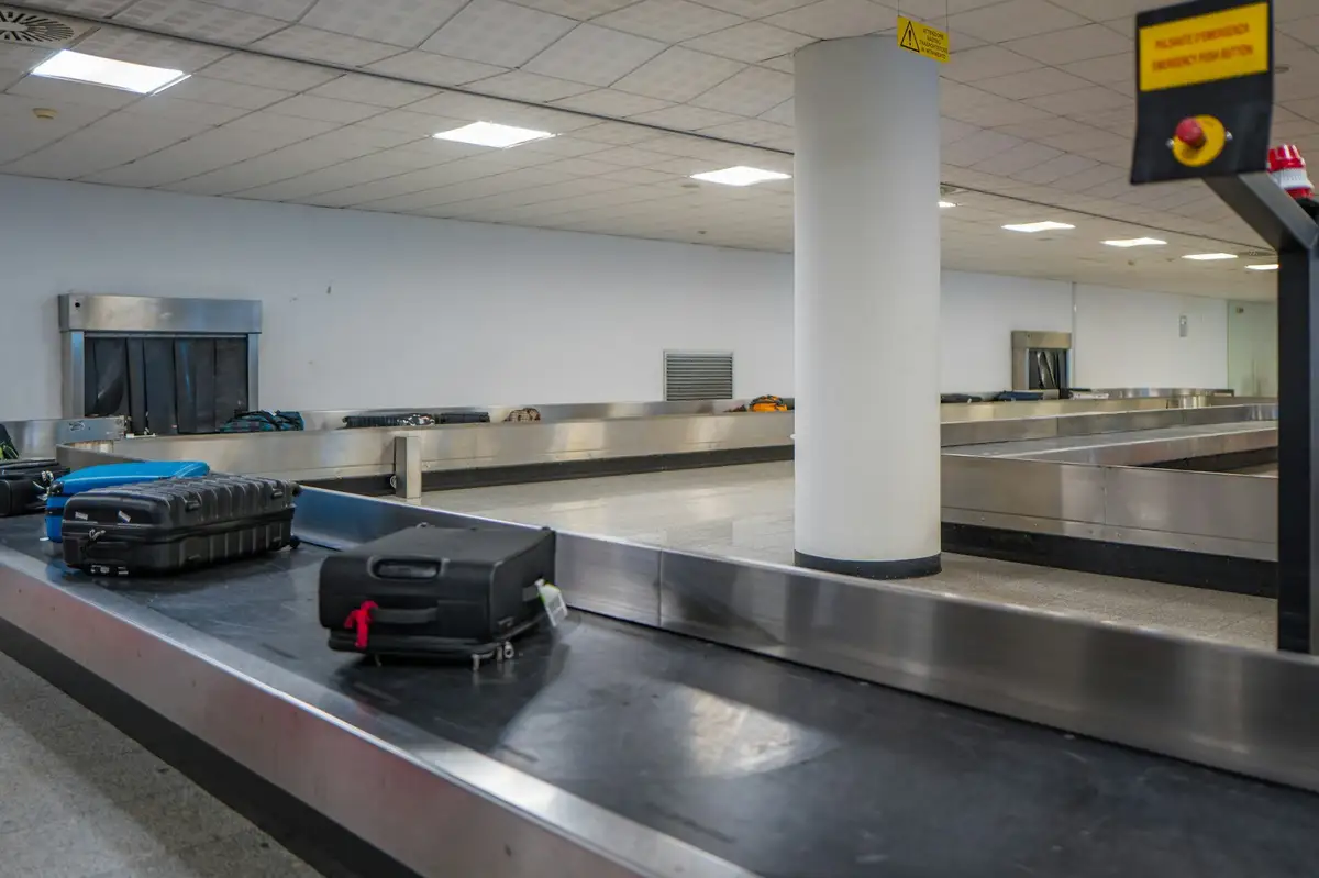 Suitcases moving along a baggage carousel in an airport arrivals hall