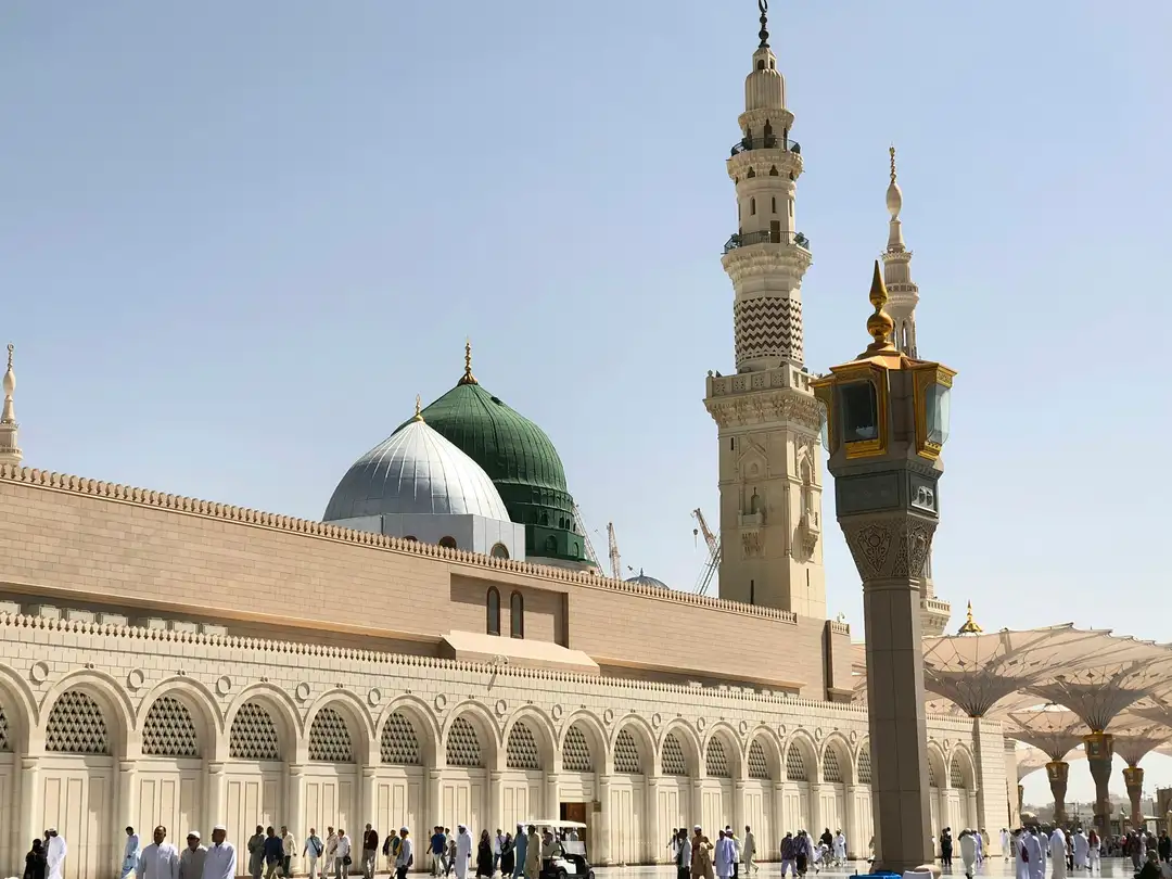 The Green Dome of the Prophet's Mosque against a bright daytime sky