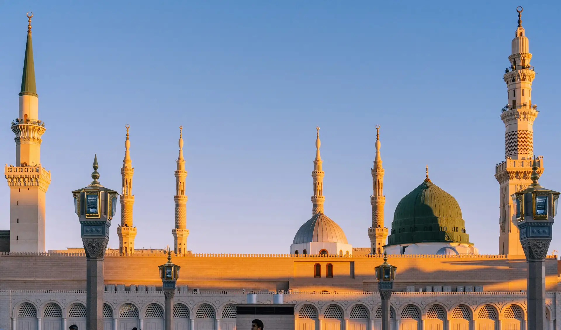 The minarets and domes of the Prophet’s Mosque in low golden light