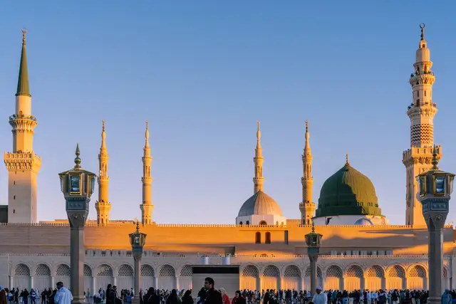 The minarets and domes of the Prophet’s Mosque in low golden light