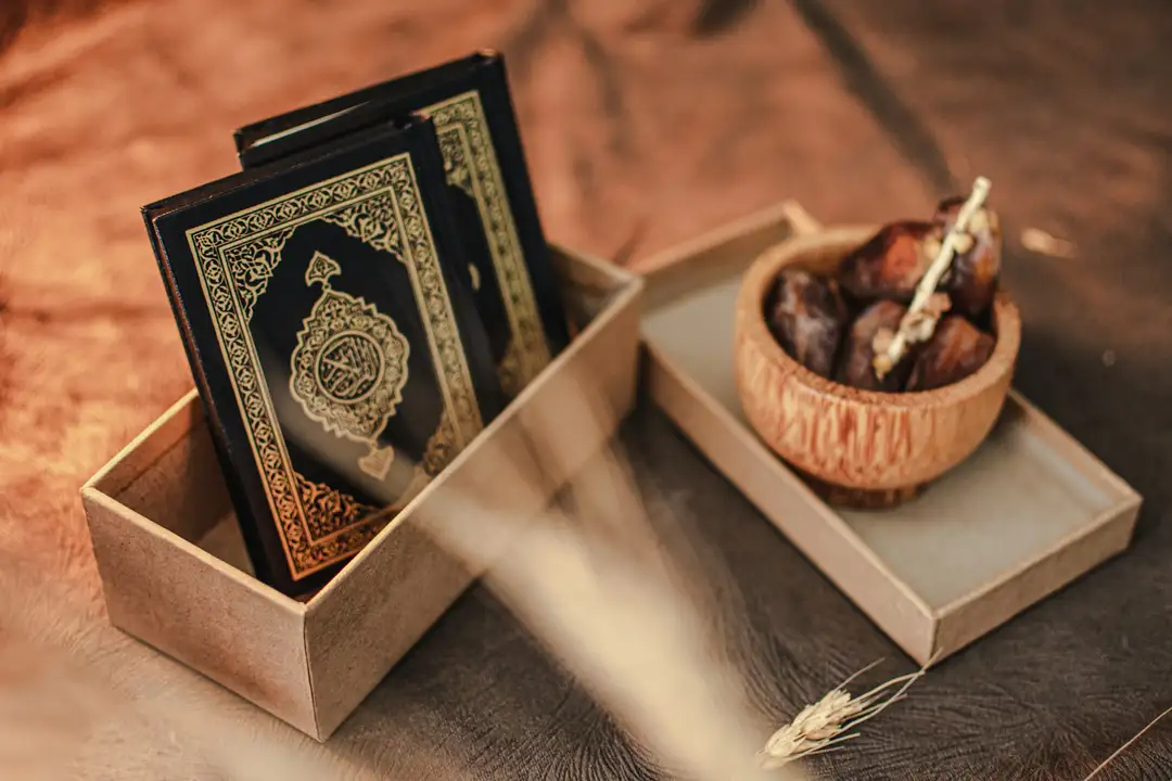 A Quran in a wooden case beside a bowl of dates