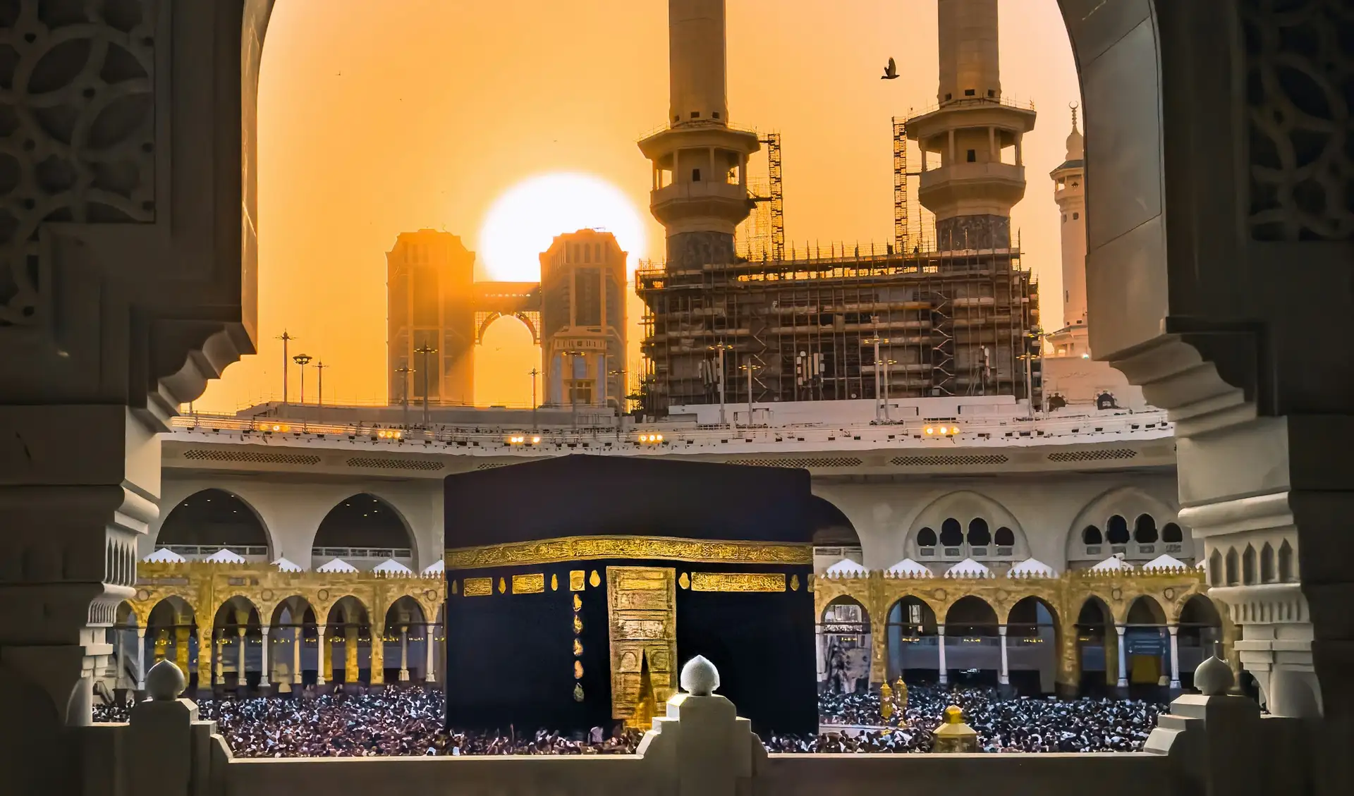 The Kaaba framed by an arch of Masjid al-Haram at sunrise