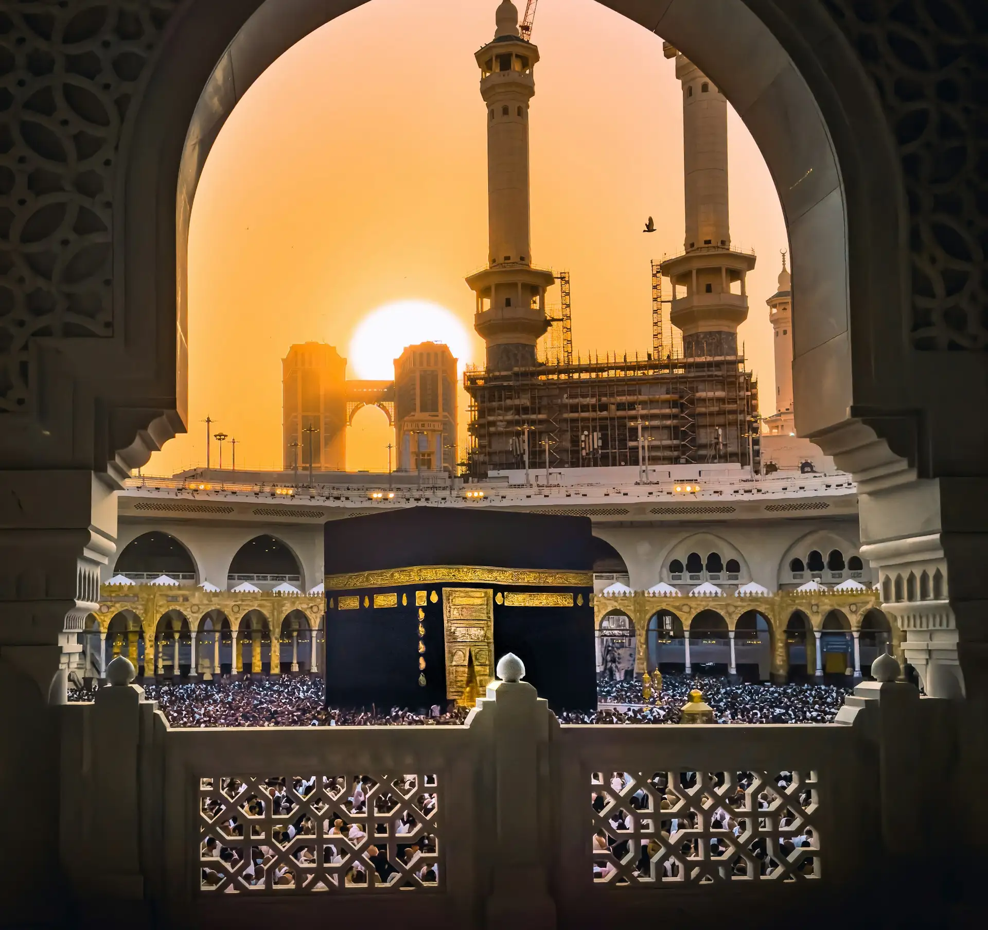 The Kaaba framed by an arch of Masjid al-Haram at sunrise