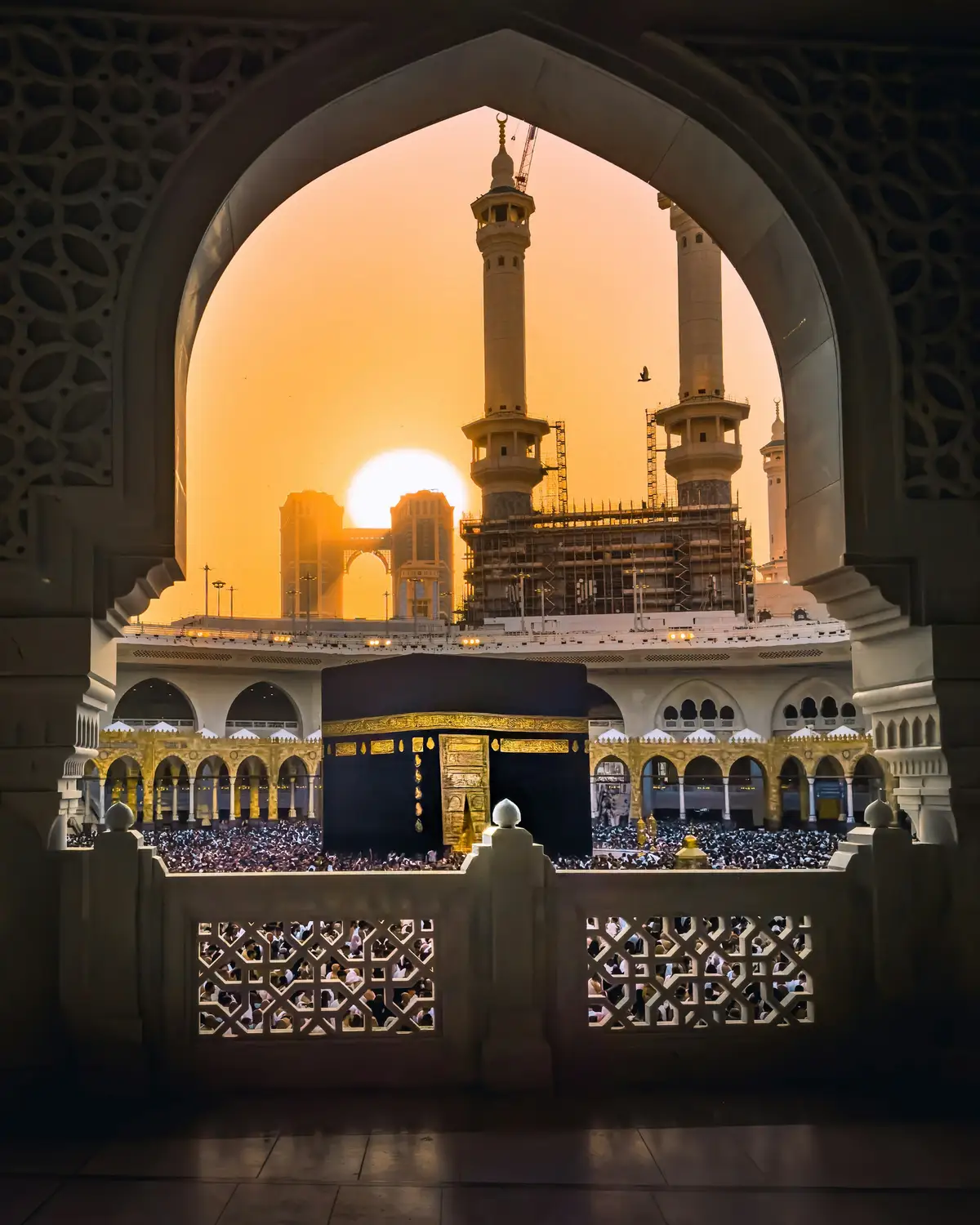 The Kaaba framed by an arch of Masjid al-Haram at sunrise