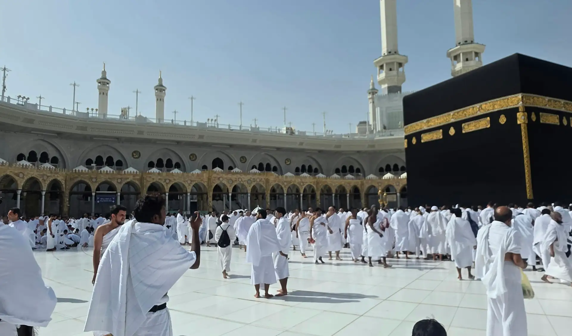 Pilgrims in ihram beside the Kaaba