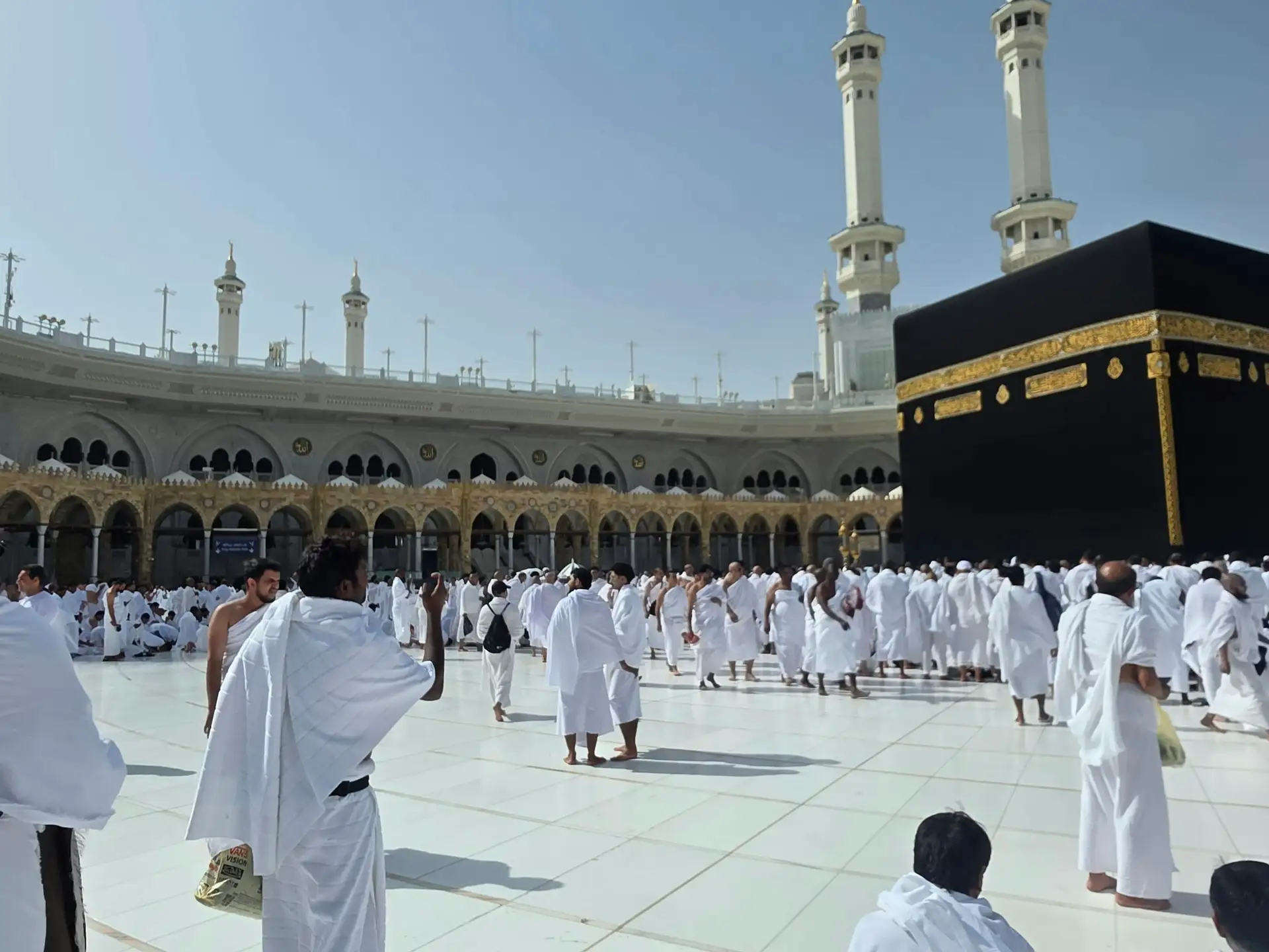 Pilgrims in ihram beside the Kaaba