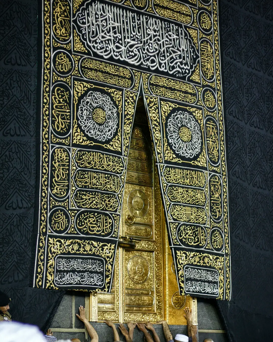 The gold door of the Kaaba set into the black kiswah embroidered with gold calligraphy