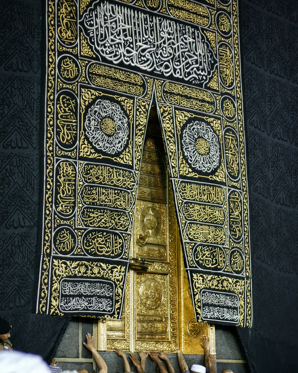 The gold door of the Kaaba set into the black kiswah embroidered with gold calligraphy