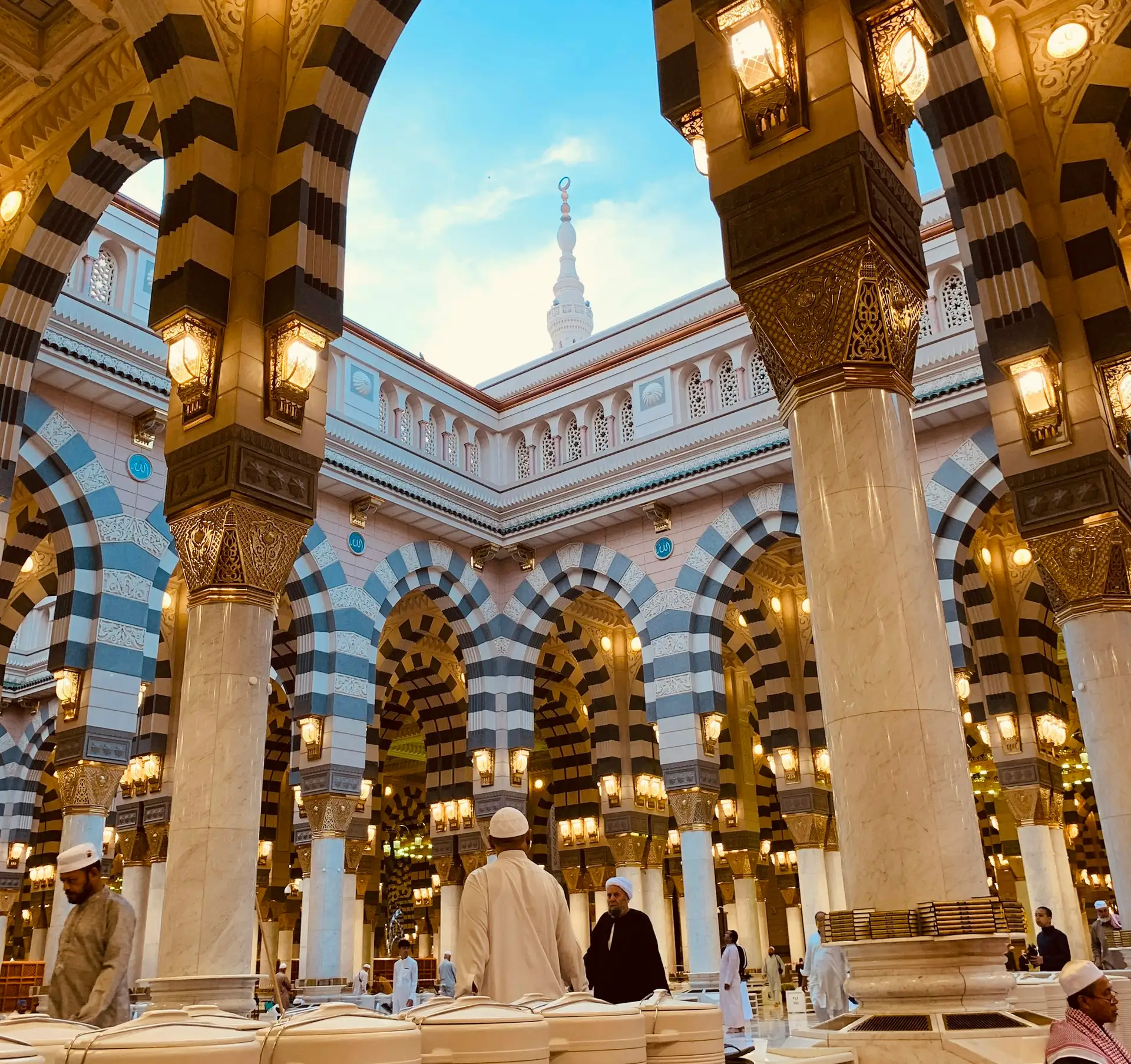 Striped arches and brass lanterns in the Prophet’s Mosque