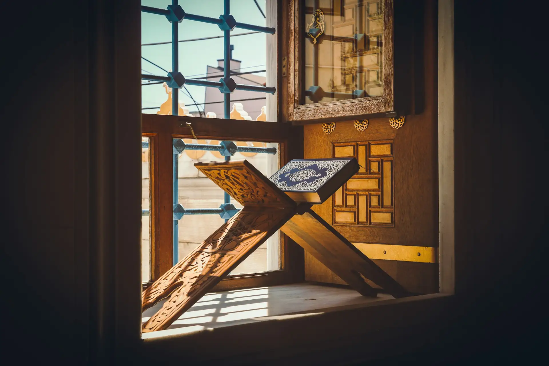 A Quran on a wooden stand in morning light